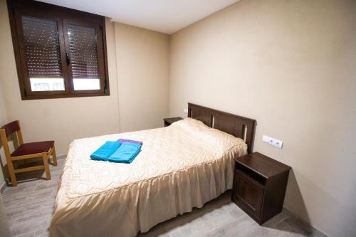 a bedroom with a bed with a blue towel on it at CASA CAL METGE in Benissanet