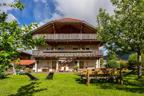 Casa con techo de madera y mesa de picnic en la hierba en Liebharterhof, en Valdaora