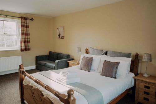 a bedroom with a large bed and a chair at Greenfinch in Lucker