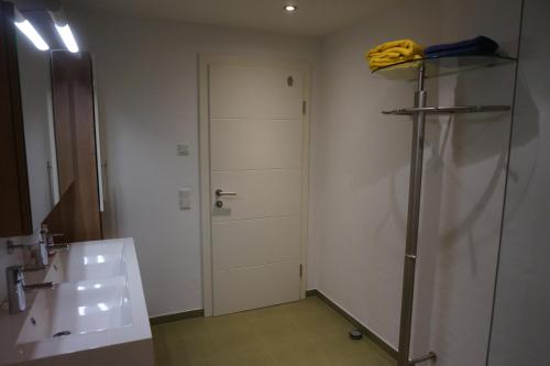 a bathroom with a sink and a white door at Appartement Deisl in Wagrain
