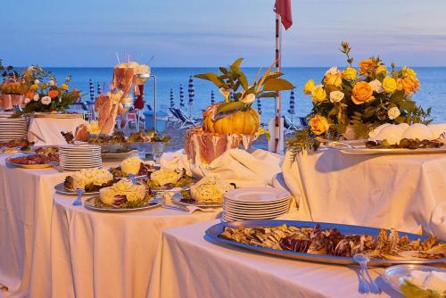 a table with plates of food on top of the ocean at Hotel Poseidon in Diamante