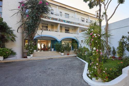 a building with flowers and plants in front of it at Hotel Poseidon in Diamante