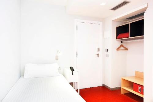 a bedroom with a white bed and white walls at Ciutat Vella in Barcelona