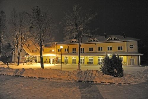 a large yellow building at night with lights at Zajazd Tip Top in Iganie