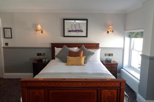 a bedroom with a large wooden bed with pillows at Admiral Hardy in London