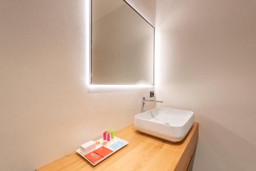 a bathroom with a white sink and a mirror at Villa Anna, Luxury and private pool in Alba