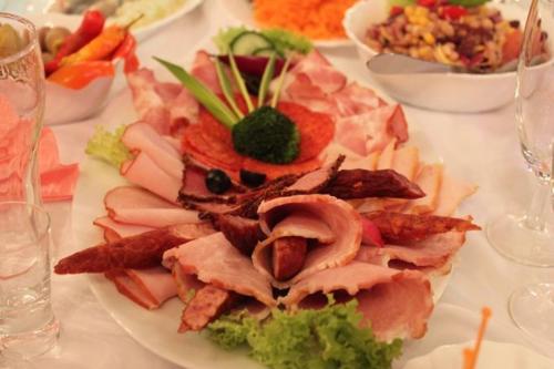 a plate of food with meat and other foods on a table at Zajazd Tip Top in Iganie