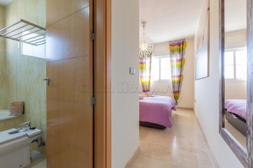 a room with a bedroom with a bed and a mirror at Residencial Duquesa 18 in Manilva