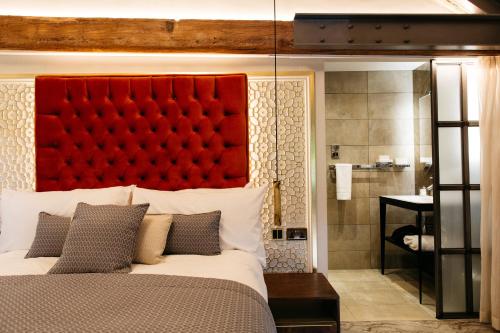 a bedroom with a large bed with a red headboard at Quite Simply French in Lancaster