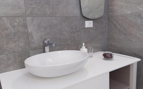 a bathroom with a white sink and a mirror at La Selce Farmhouse in Bagnaria Arsa