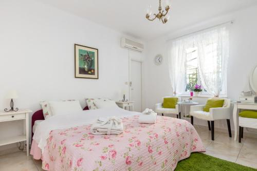 a white bedroom with a bed and a table and chairs at For All Seasons Apartment in Split