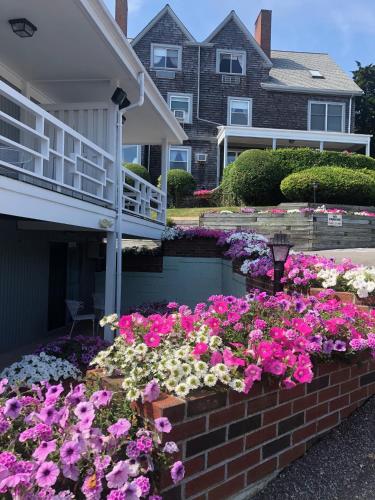 a garden of flowers in front of a house at Sands Of Time Motor Inn & Harbor House in Woods Hole