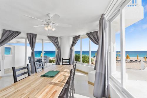 a dining room with a table and a view of the beach at Turtle's Nest Beach Resort in Meads Bay