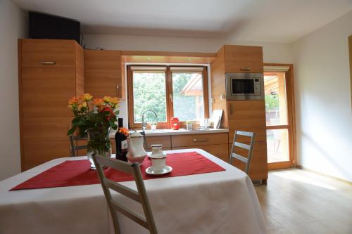 a kitchen with a table with a vase of flowers on it at Domek Anielski in Zator