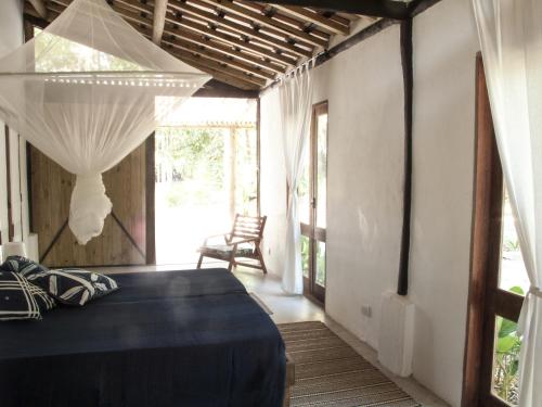 a bedroom with a bed in a room with a window at The Lion Cottage- Charming Studios in Santo André