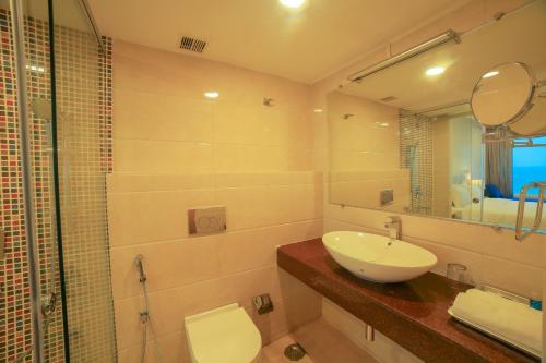a bathroom with a sink and a toilet and a shower at Bay View Hotel Vizag in Visakhapatnam