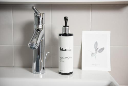a bottle of moisturizing cream next to a faucet on a counter at B&B Hof Beygaert in Aalst