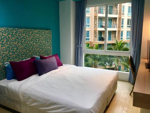 1 dormitorio con 1 cama y ventana grande en Atlantis Jomtien Waterworld Resort en Jomtien Beach
