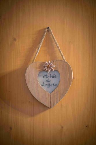 a wooden heart shaped sign hanging on a wall at Baita Luleta in Livigno