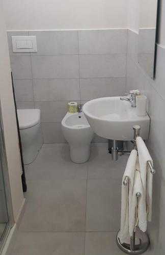 a white bathroom with a sink and a toilet at Casa Maria in Modica