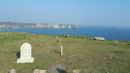 a stone monument on top of a hill with the ocean at Gite d'artiste 50m de la mer in Camaret-sur-Mer