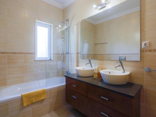 een badkamer met 2 wastafels, een douche en een bad bij Luxury Holiday Villa Alegria Galé Beach, Albufeira in Albufeira