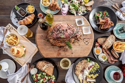 a table topped with plates of food and sandwiches at Wild Clover Cottages in Stellenbosch