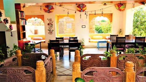 - un salon avec une table, des chaises et un piano dans l'établissement The Wanderlust Guest House & Safari, à Jaisalmer