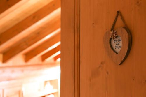 a wooden heart hanging on a wall with a door at Baita Luleta in Livigno