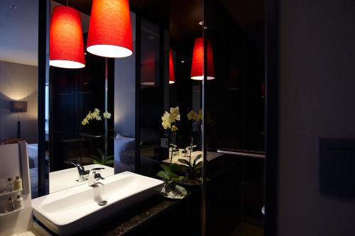 a bathroom with a sink and two red lights at Best Louis Hamilton Hotel Haeundae in Busan