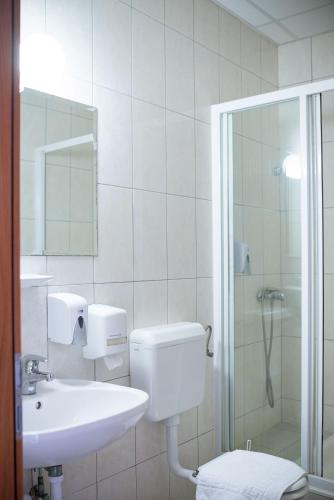 a bathroom with a toilet and a sink and a shower at Wellness Hotel Szindbád in Balatonszemes