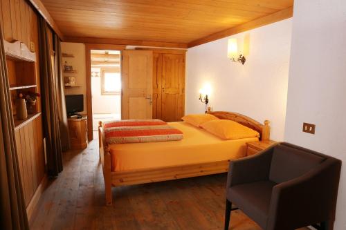 a bedroom with a bed and a chair in it at Baita Luleta in Livigno