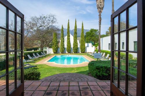 a view from a window of a pool and trees at Webersburg in Stellenbosch