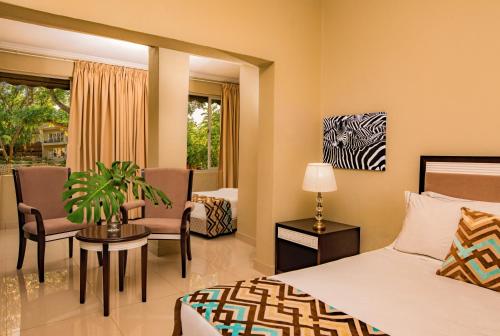 um quarto de hotel com um quarto com uma cama e um quarto em Lotus by Serendib em Blantyre