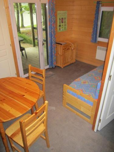 une pièce avec une table et un lit et une table et des chaises dans l'établissement Chalet de La Héronnière, à Chef-Boutonne