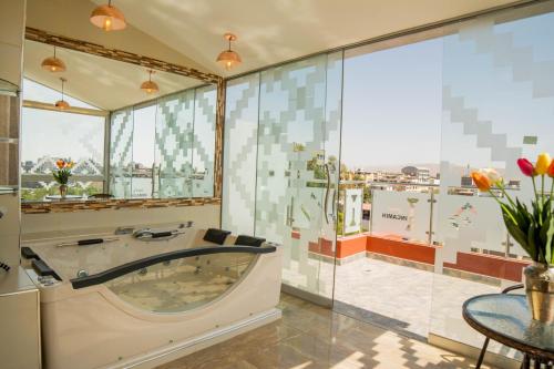 baño grande con bañera y mesa en Hotel Incamin Mirador, en Arequipa