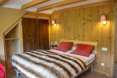 Schlafzimmer mit einem großen Bett und Holzwänden in der Unterkunft le gîte du Wildbach in Wildersbach