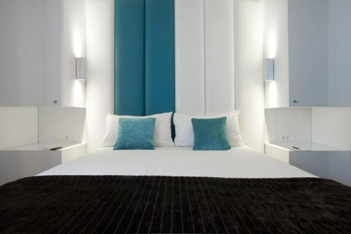 ヘンクにあるホテル エキュのベッドルーム(青色をアクセントにした白い大型ベッド1台付)