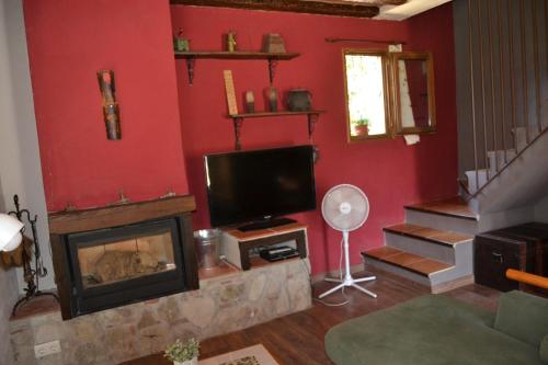 a living room with a fireplace and a tv at Casa JUNIA in La Baronia de Sant Oisme