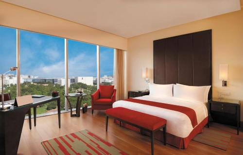 a hotel room with a bed and a desk and chair at Trident Hyderabad in Hyderabad