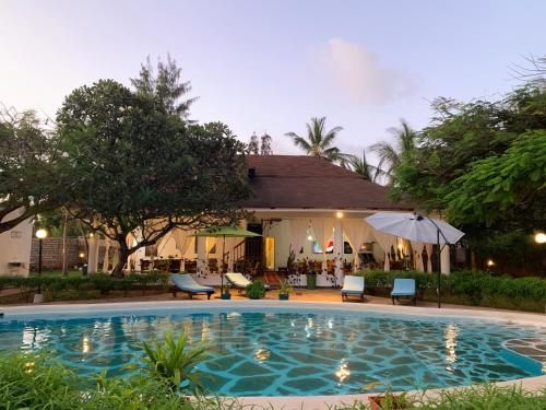 a swimming pool in front of a house at Villa Ameera Malindi in Malindi