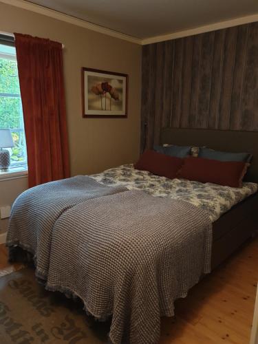 een slaapkamer met een bed met een dekbed en een raam bij Spiragården in Glanshammar