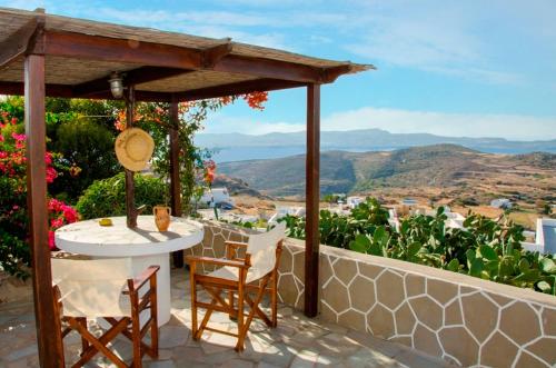 a table and chairs on a patio with a view at Drougas' Windmill in Plaka Milou