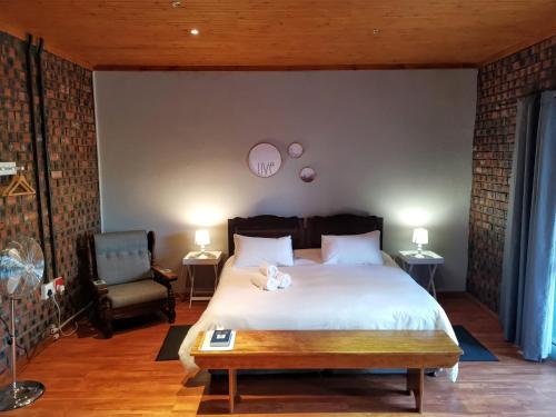 Un dormitorio con una cama con un osito de peluche. en En Route Guest House, en Trompsburg