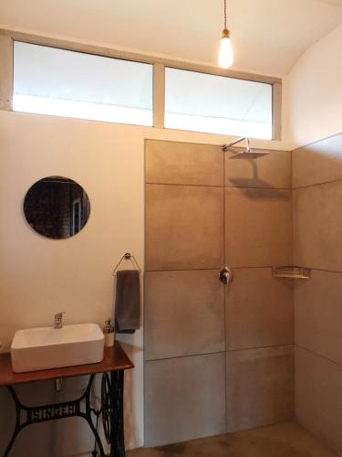 a bathroom with a shower and a sink at En Route Guest House in Trompsburg
