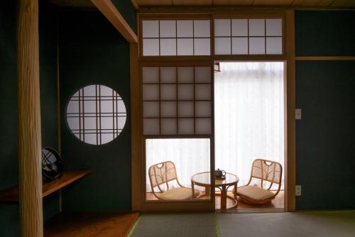 Zimmer mit einem Tisch, Stühlen und einem Fenster in der Unterkunft Sapporo - House / Vacation STAY 4995 in Sapporo