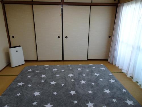 Un dormitorio con una alfombra gris con estrellas. en Merbeil Otsuka / Vacation STAY 4984, en Nikaidō