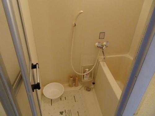 baño pequeño con bañera y aseo en Merbeil Otsuka / Vacation STAY 4984, en Nikaidō