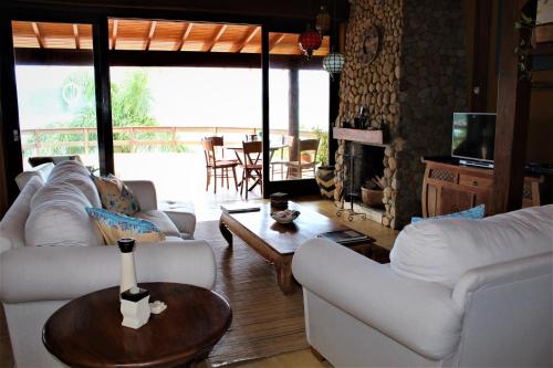 a living room with two white couches and a table at Luxury Suites Vila Indonésia in Garopaba
