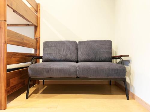a gray couch sitting in a room next to a staircase at Cactus Inn / Vacation STAY 51554 in Miyazaki